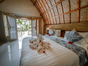 a bedroom with a large bed with towels on it at Mertha Sari Resto & Bungalow in Klungkung