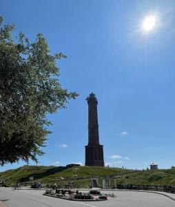 a lighthouse on top of a hill with a blue sky at Haus Andersen Apartment ZWEI in Norderney