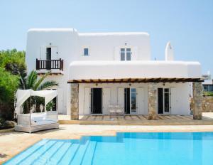 a villa with a swimming pool in front of a house at Dreamy Boho 5bed Villa with Pool and Ocean View in Mikonos