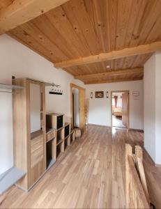 een lege kamer met houten plafonds en houten vloeren bij Ferienwohnung Biohof Untermar in Obervellach