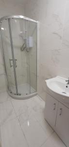 a white bathroom with a shower and a sink at Leicester City Apartments in Leicester
