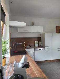 una cucina con armadietti bianchi e pavimenti in legno di Ferienwohnung Biohof Untermar a Obervellach