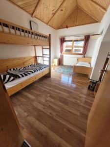 een slaapkamer met 2 stapelbedden en een houten vloer bij Ferienwohnung Biohof Untermar in Obervellach