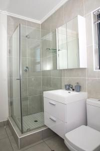 a bathroom with a shower and a toilet and a sink at Eirini Elegant - Athena Apartment Fourways in Sandton