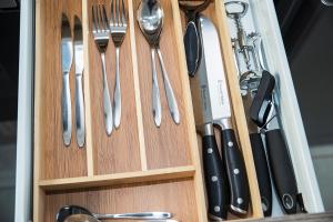 a wooden drawer with utensils in it at Eirini Elegant - Athena Apartment Fourways in Sandton