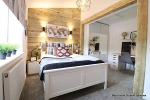 a bedroom with a bed and a desk and a mirror at Leicester City Apartments in Leicester