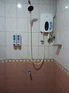 a shower in a bathroom with a shower head at AeCOTEL in Sandakan
