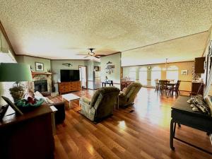 a living room with a couch and chairs and a television at Orange Beach! Spacious mobile home near the beach! in Orange Beach