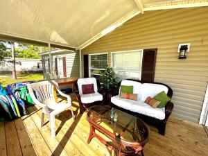 a porch with two chairs and a glass coffee table at Orange Beach! Spacious mobile home near the beach! in Orange Beach