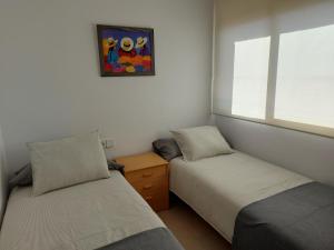 1 dormitorio con 2 camas y ventana en Apartamentos CT en Salou