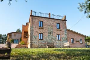 un gran edificio de ladrillo con un balcón en la parte superior. en Fattoria di Pieve Pagliaccia - Cantina Brugnoni, en Perugia