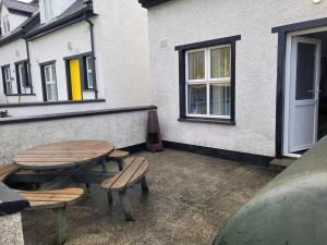 a patio with a table and benches and a building at Cottage by the sea Greencastle in Greencastle