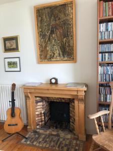 a living room with a fireplace and a guitar at La Chambre de L'Embarcadère in Le Conquet