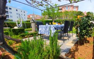 a table with a blue table cloth on it in a garden at Apartments Villa Bare in Kastav