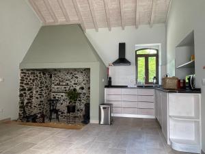 uma cozinha com uma lareira de pedra num quarto em Quinta do Areal em Lousã