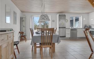 a kitchen and dining room with a table and chairs at Holiday Home Stenbjerg Kirkevej in Stenbjerg