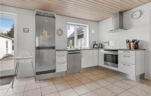 a kitchen with stainless steel appliances and a window at Holiday Home Stenbjerg Kirkevej in Stenbjerg