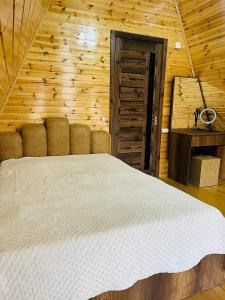 sypialnia z dużym łóżkiem w drewnianym pokoju w obiekcie House of memories w mieście Surami