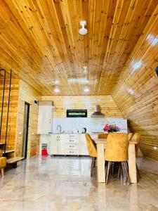 a kitchen with a wooden ceiling and a table and chairs at House of memories in Surami