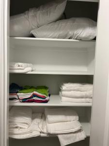 een kast met handdoeken, kussens en handdoeken bij Beautiful Smart Home in Spring
