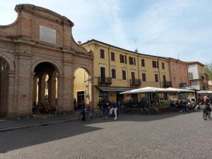 um grupo de pessoas sentadas em mesas em frente aos edifícios em Appartamento in piazza CAVOUR centro storico Rimini em Rimini