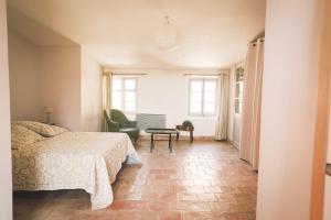 a bedroom with a bed and a chair at Château Barbebelle in Rognes