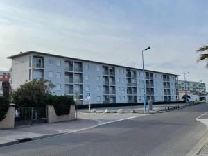 a large white apartment building on a street at SOL Y MAR Location 4 personnes St Cyprien 2 étoiles FNAIM in Saint-Cyprien