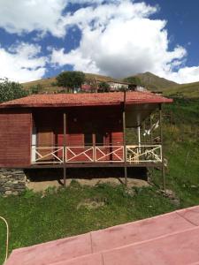 a small house with a red roof on a hill at B & B Juta in Stepantsminda +4 photos