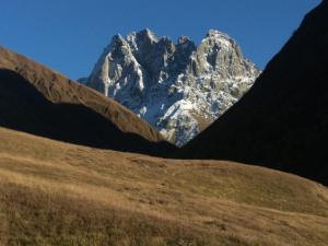 a snow covered mountain in the middle of a field at B & B Juta in Kazbegi +4 photos