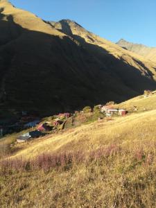 un pequeño pueblo en una colina frente a una montaña en B & B Juta en Kazbegi