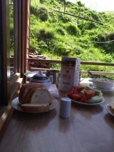 a table with a loaf of bread and a box of milk at B & B Juta in Stepantsminda