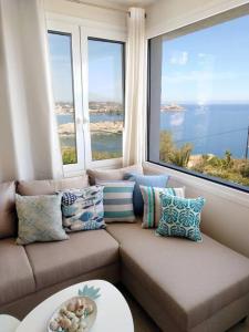 un soggiorno con divano e ampie finestre di Chatzidakis Apartment/Inspiration harmony a Ligaria