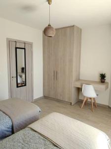 a bedroom with a bed and a cabinet and a table at Chatzidakis Apartment/Inspiration harmony in Lygaria