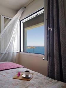 un letto con un piatto con una tazza e una finestra di Chatzidakis Apartment/Inspiration harmony a Ligaria
