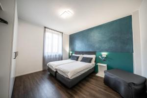 a bedroom with a bed and a green wall at Appartamenti Vasco Renna Surf Center in Nago-Torbole