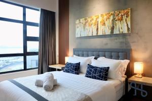 a bedroom with a large white bed with blue pillows at Homesuite' Home at Jesselton Quay in Kota Kinabalu