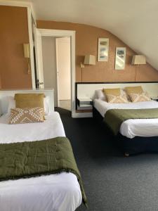 a hotel room with two beds in a room at Hôtel Céline - Hôtel de la Gare in Rouen