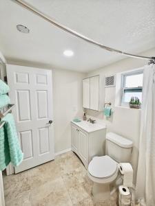a bathroom with a toilet and a sink and a window at Amazing guest unit central location in St Petersburg