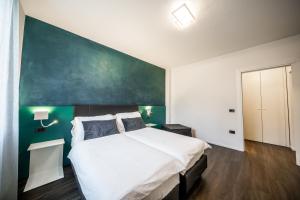 a bedroom with a large bed and a green wall at Appartamenti Vasco Renna Surf Center in Nago-Torbole