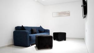 un sofá azul y un taburete en la sala de estar en Appart AYAMOUS MARINA en Kenitra