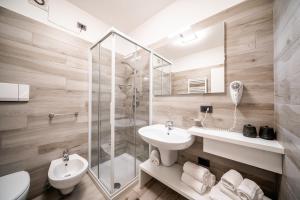 uma casa de banho com um chuveiro, um lavatório e um WC. em Appartamenti Vasco Renna Surf Center em Nago-Torbole