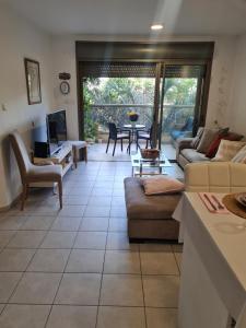een woonkamer met een bank en een tafel bij Amazing Apartment in Raanana & Swimming up to 4 guests pool and Jacuzzi in Ra‘ananna