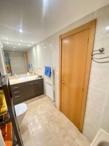 a bathroom with a toilet and a sink and a door at Coast apartment near Barcelona in Sant Andreu de Llavaneres