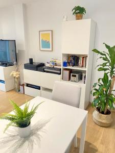 a living room with a white table and plants at Coast apartment near Barcelona in Sant Andreu de Llavaneres