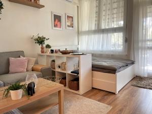 een kleine woonkamer met een bed en een bank bij Balaton Breeze Apartman in Fonyód