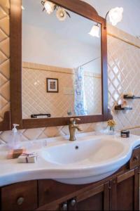 a bathroom with a sink with a large mirror at La Villa del Conte in Scicli