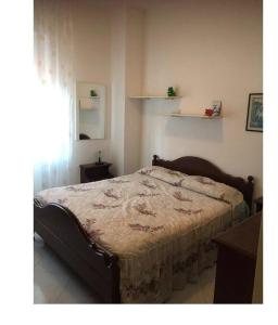 una camera con un letto in una stanza con una finestra di Serena e tranquilla casa vacanze in centro a Cirò Marina