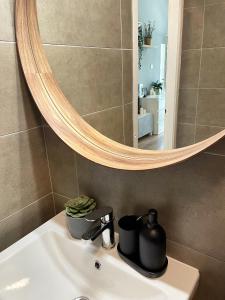 a bathroom sink with a mirror and a kettel at Balaton Breeze Apartman in Fonyód