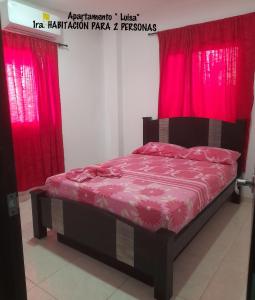 a bed in a room with red curtains at Apartamento JHON in Coveñas