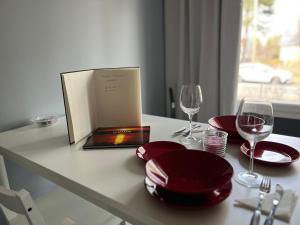a table with red plates and glasses and a book at Wiitakoto in Viitasaari